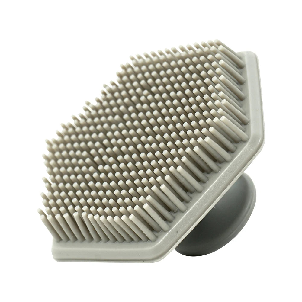 A gray silicone body scrubber and massage brush with numerous short, tapered bristles.