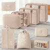 A set of beige and cream travel packing cubes and storage organizer bags displayed on a white surface.