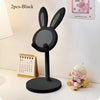 A black rabbit-shaped stand for a mobile phone or tablet, shown next to a calendar and a small plush toy.