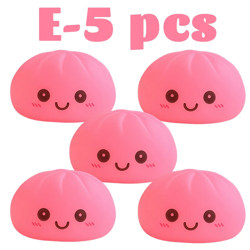 Cinco juguetes blandos rosas con forma de dumplings y caras lindas