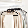 A rack of black velvet hangers displaying various colored t-shirts and tops.