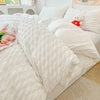 A white lightweight seersucker duvet cover set displayed on a bed with white pillows and a light beige rug.