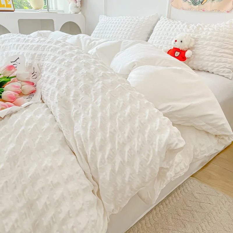 A white lightweight seersucker duvet cover set displayed on a bed with white pillows and a light beige rug.