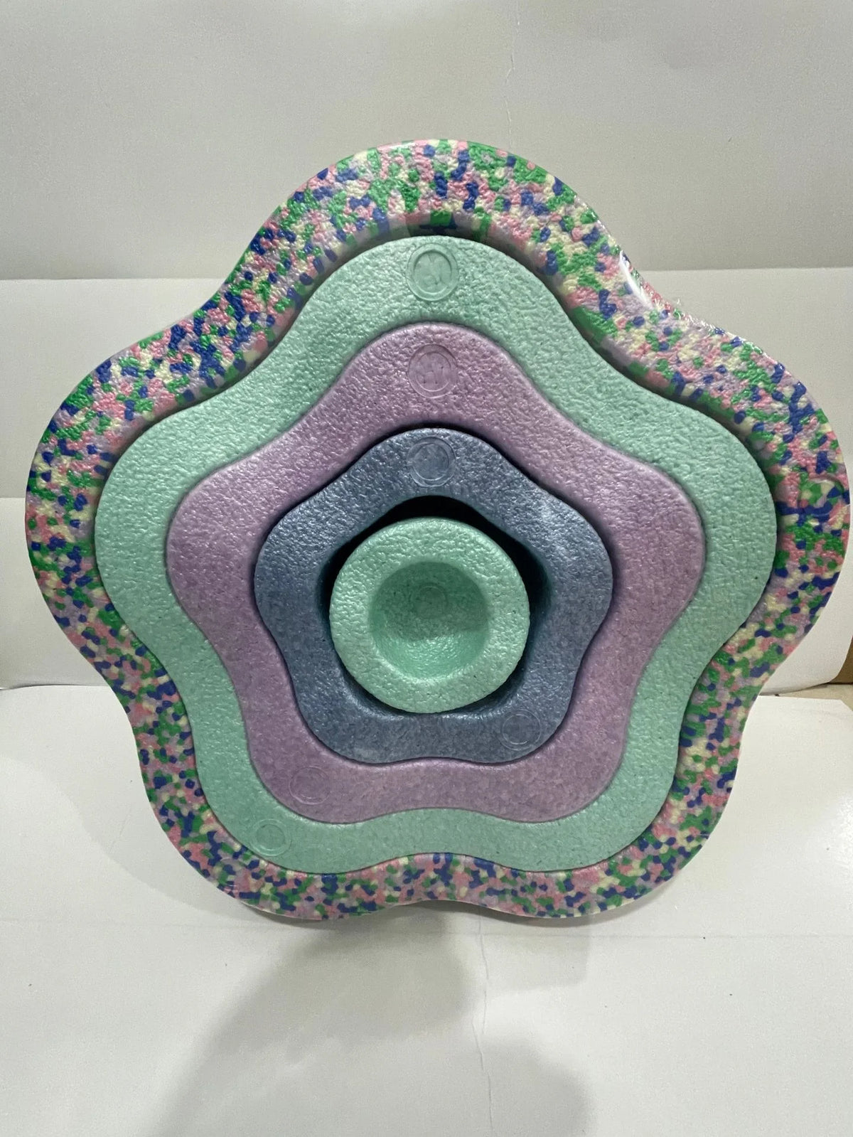 A colorful, multi-layered plastic balance stepping stone with a floral pattern.
