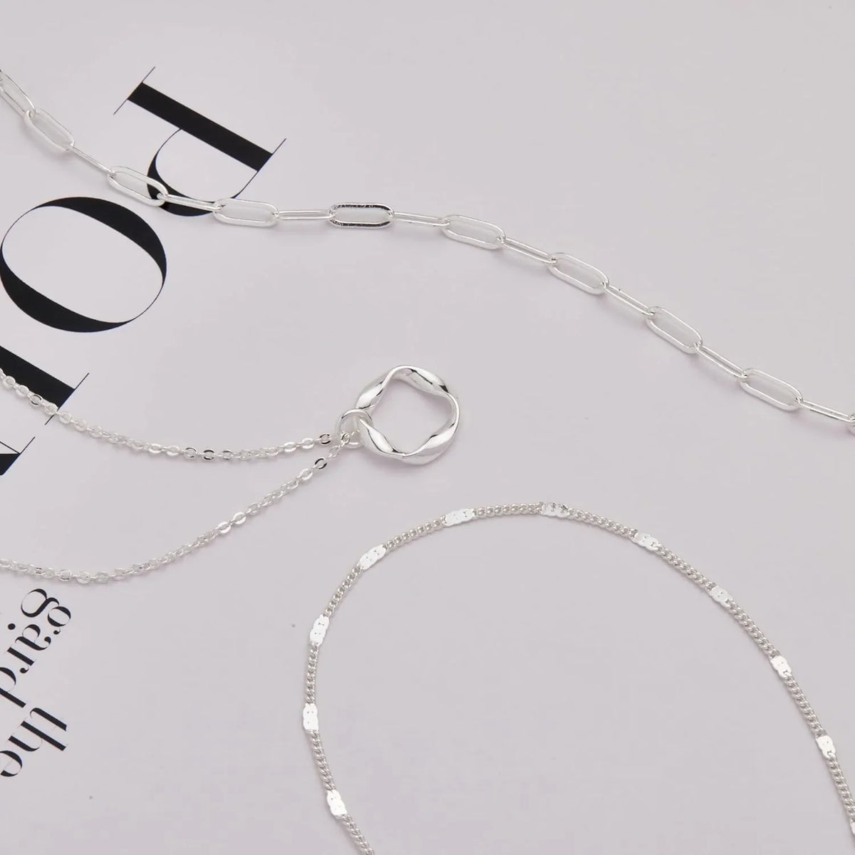A set of layered gold and silver chain necklaces displayed against a white background.