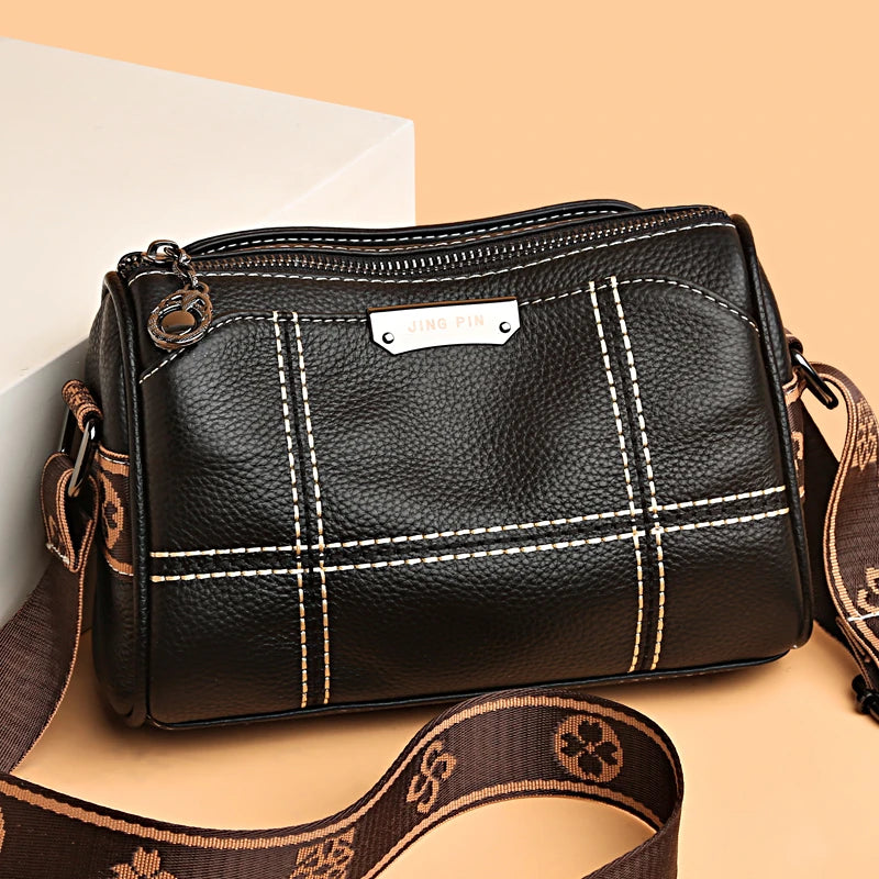 A black vintage genuine leather women's shoulder bag with a gold hardware detail and brown strap.