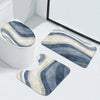 A set of three striped bathroom rugs, including a U-shaped toilet mat and cover, displayed on a white surface.