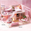 A pink wooden dollhouse miniature building kit featuring furniture and a bedroom setup.