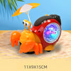An orange and black interactive crawling crab toy with a glowing blue light is shown on a sandy surface.