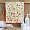 A pure cotton embroidered cartoon face towel hanging on a wooden rod with soap bottles nearby.