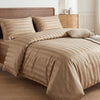 A beige satin striped jacquard duvet cover set displayed on a bed with wooden furniture.