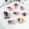 A collection of enamel pins featuring American flag designs, including a cross, a silhouette, and a flag outline.