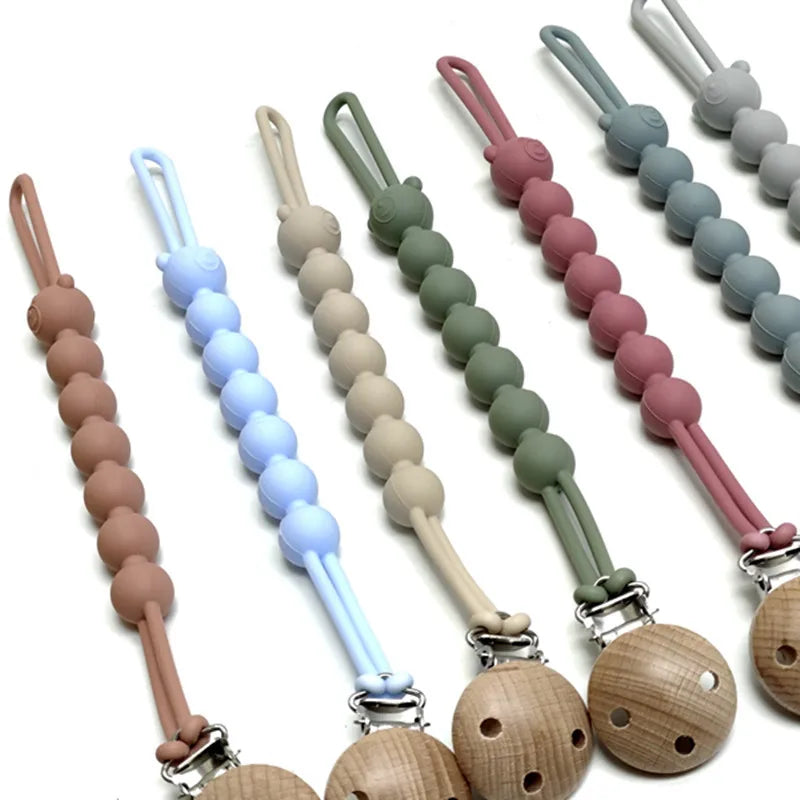 A set of food-grade silicone pacifier clips with anti-lost chains in various pastel colors.