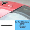 Close-up view of a red Ford Mustang interior trim piece featuring black carbon fiber grain decorative trim.