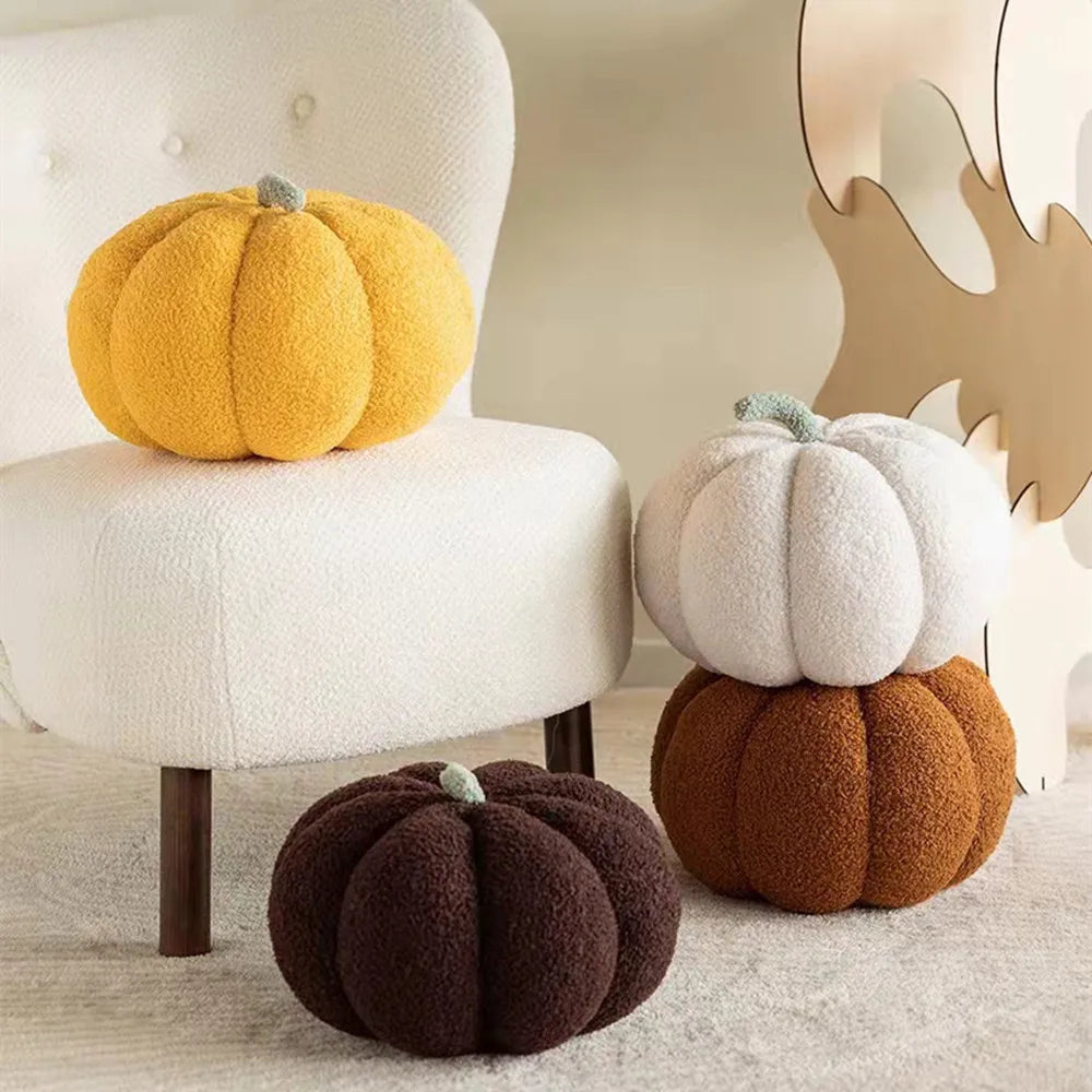 A collection of soft, fluffy decorative pumpkins in yellow, white, and brown fabric cushions.