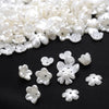 A pile of small, white acrylic pearl spacer beads for jewelry making.