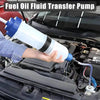A hand is holding a white fuel oil fluid transfer pump connected to an engine component.