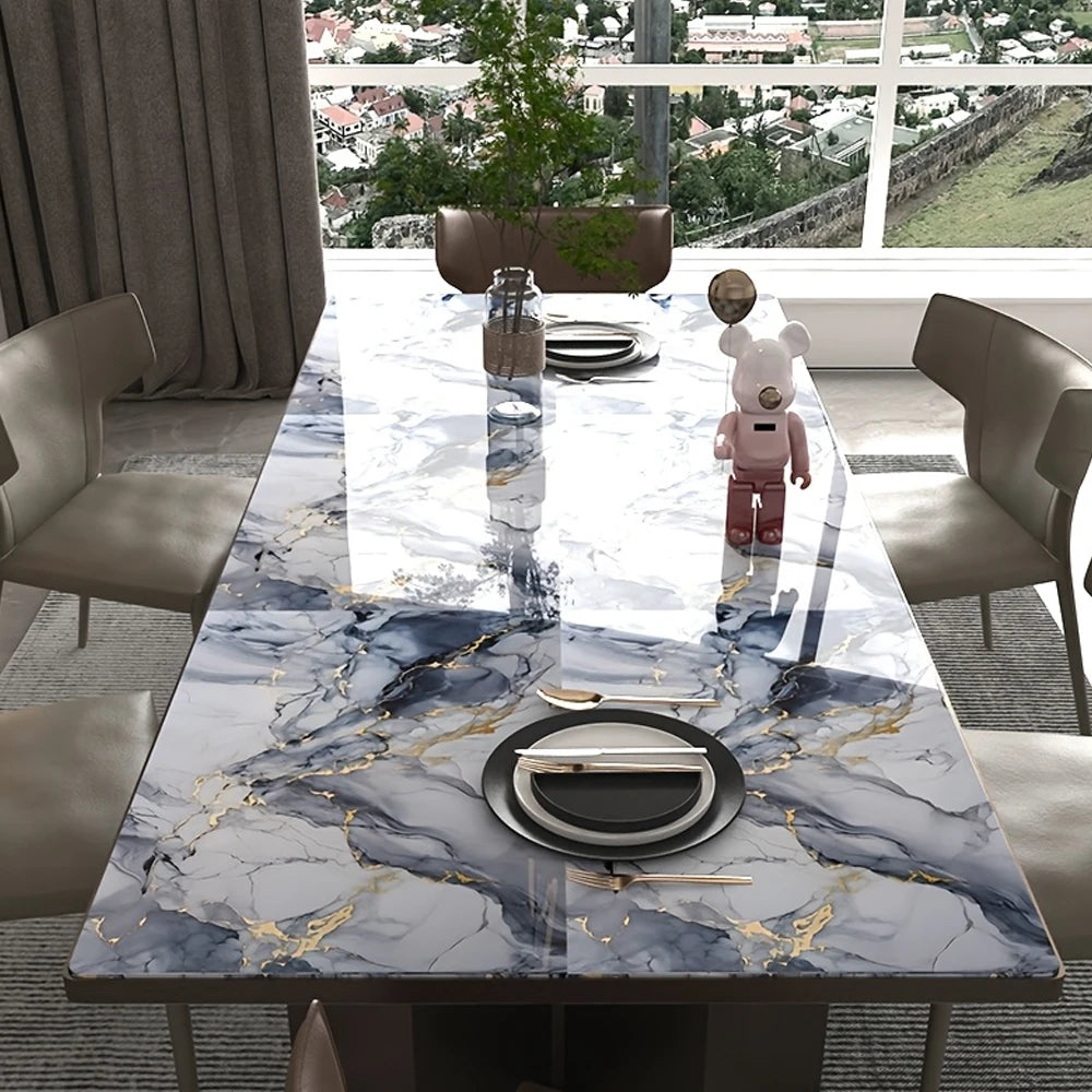 A marble-patterned dining table with gold veining, set for a meal, in a modern room.