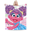 A plush blanket featuring a cartoon character with pink skin and purple hair against a light background.