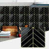 Black and gold herringbone marble peel-and-stick wall tiles installed on a kitchen backsplash.