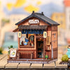 A detailed miniature Japanese book nook kit featuring a traditional wooden shop facade and lighting elements.