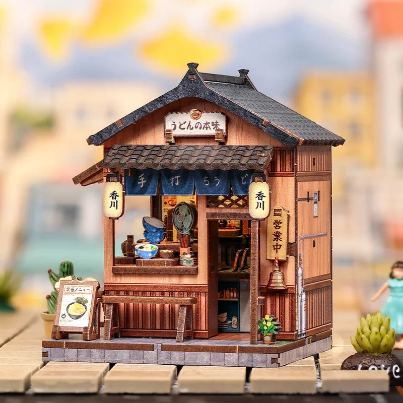 A detailed miniature Japanese book nook kit featuring a traditional wooden shop facade and lighting elements.