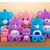 Una colección de peluches Care Bears de arcoíris de colores, en varios tonos de azul, rosa y morado.