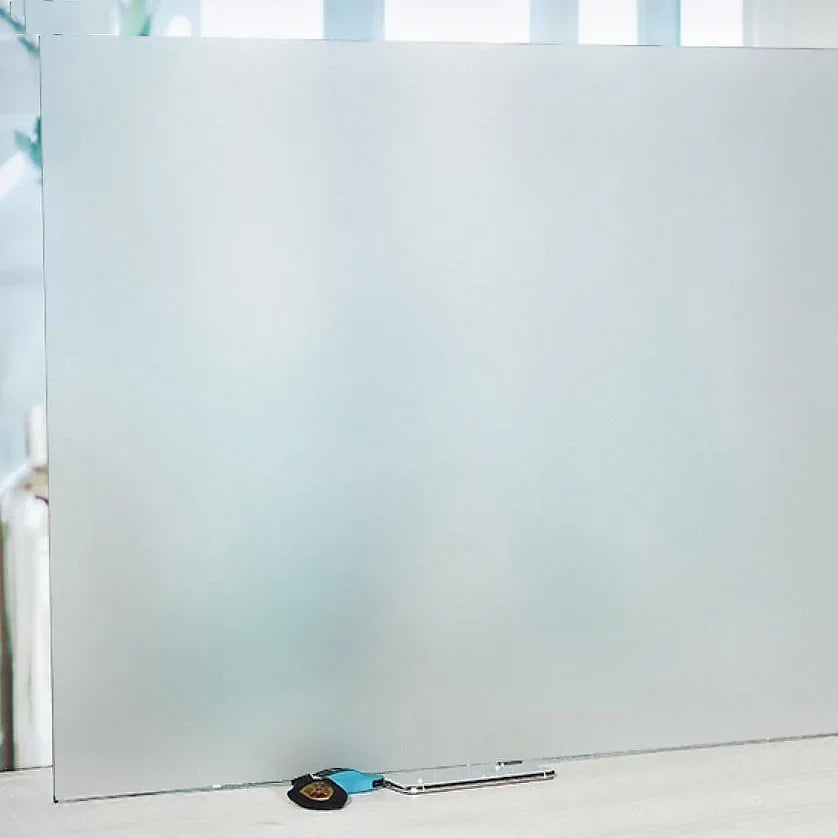 A clear frosted privacy window film panel with a stripe pattern resting on a white surface.