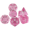 A set of seven transparent pink crystal polyhedral dice for tabletop role-playing games
