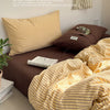 A brown bed with a striped yellow duvet cover and pillows, featuring text about atmosphere sense.