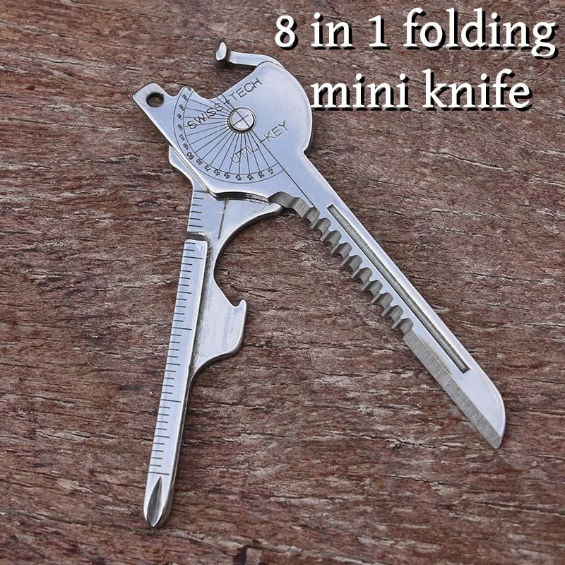 A silver folding mini knife with a SwissTech key and blade visible on a wooden surface.