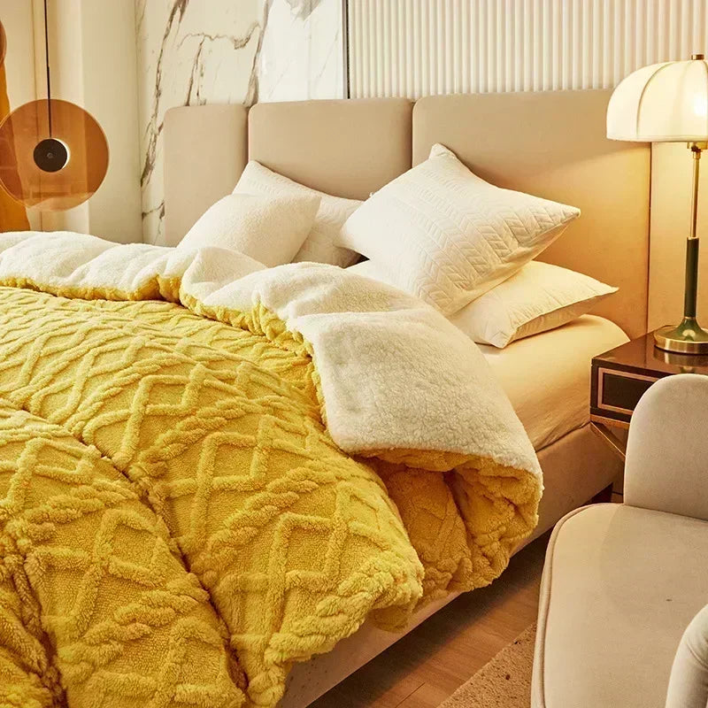 A yellow quilted duvet cover and blanket with a cream trim is displayed on a bed in a bright room.