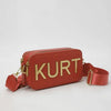 Terrakotta-roter Lederbeutel mit goldenen Buchstaben KURT