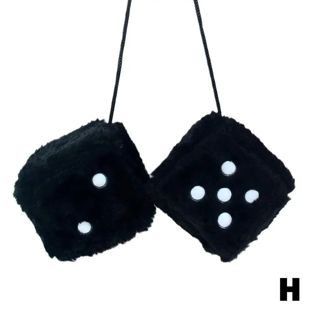Black plush velvet dice with white dots suspended on a black cord