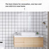 A modern bathroom vanity featuring a white sink and light wood cabinet with self-adhesive tile stickers on the walls.