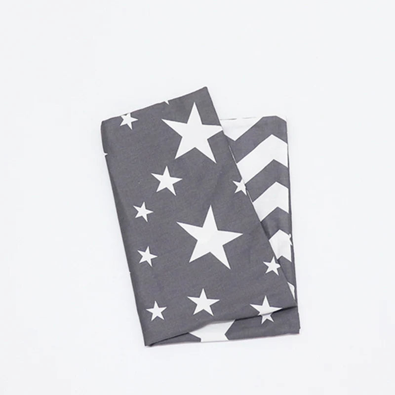 A gray and white patterned baby pillowcase featuring a patriotic star design.