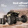 A yellow rock offroad climbing car is shown in mid-air over rough terrain.