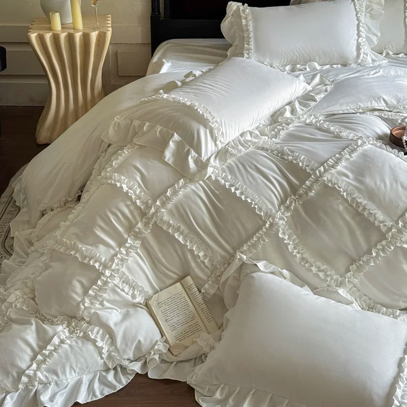 A luxurious white ruffled duvet cover set with matching pillowcases and a book on a bed.