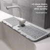 A silicone faucet drain mat is shown installed in a sink, featuring five slope drains for quick water drying.