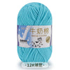 A ball of light blue milk cotton blend yarn labeled in Chinese and English.