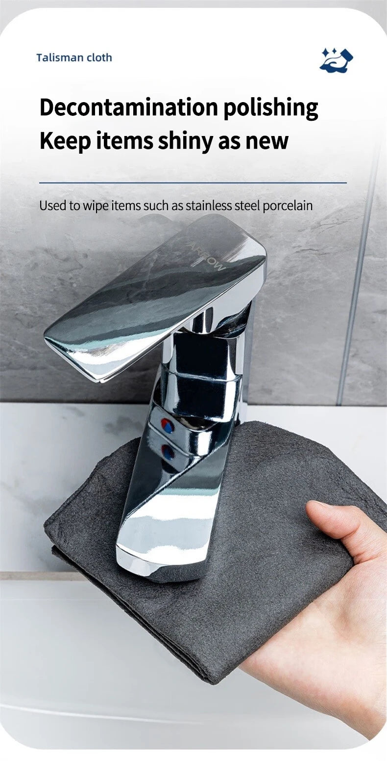 A hand holds a dark cleaning cloth wiping a shiny stainless steel porcelain item.
