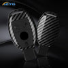 A pair of black slim carbon fiber car key covers displayed on a dark surface.