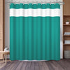 A teal shower curtain featuring a white geometric stripe pattern hanging on a rod.