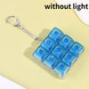 A clear blue LED mechanical keychain fidget toy with custom keycaps is displayed on a light yellow background.