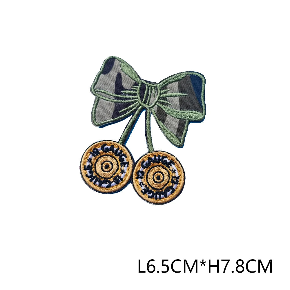 A dark green embroidered hunting patch featuring a bow and two circular patches on a fabric background.