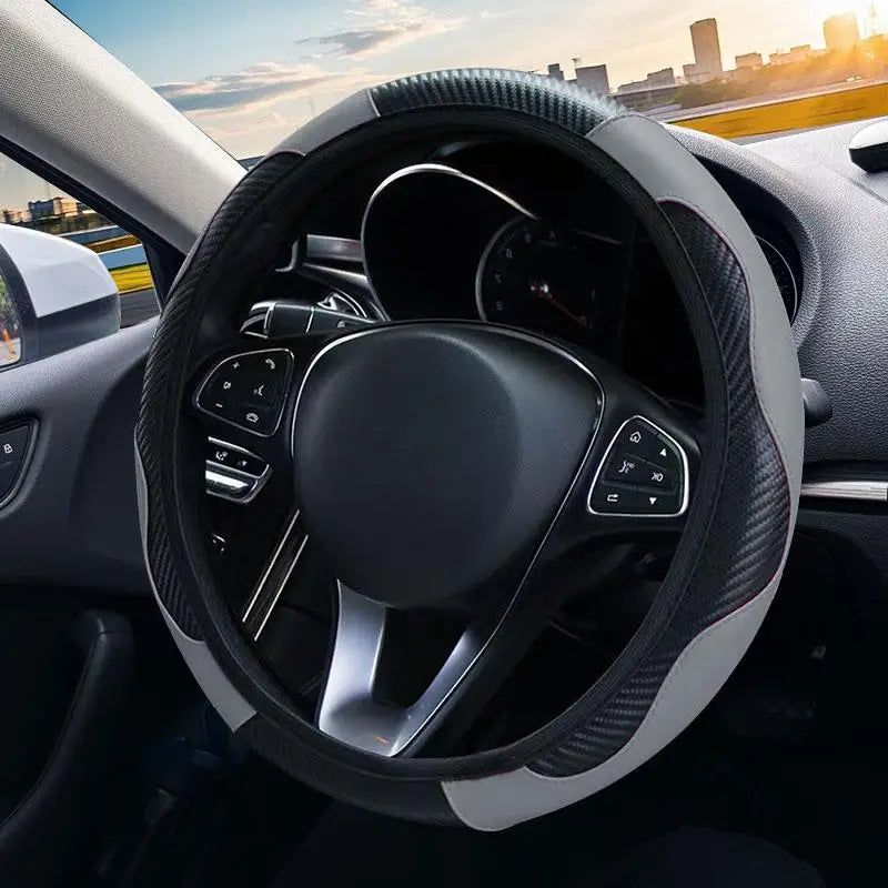 Interior view of a car showing a black steering wheel with a leather cover and controls.