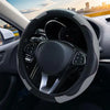 Interior view of a car showing a black steering wheel with a leather cover and controls.