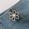 Silver pearl flower waist clip attached to a denim fabric