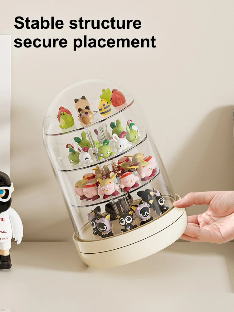 A clear rotating display case holds various small collectible figures and keepsakes on a light-colored surface.
