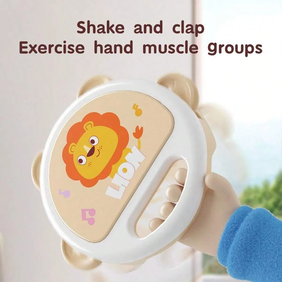 A hand-shaped clapping tambourine with a lion design is held by a child's hand.